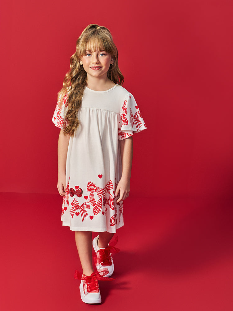 VESTIDO INFANTIL LISO COM ESTAMPA DE LACOS E CORACOES VERMELHOS NA MANGA E NA BARRA