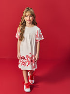 VESTIDO INFANTIL LISO COM ESTAMPA DE LACOS E CORACOES VERMELHOS NA MANGA E NA BARRA